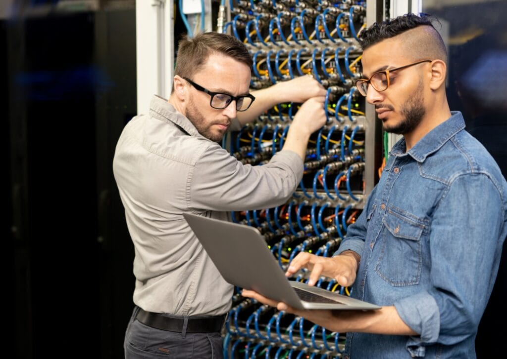 LINX technicians reviewing secure facility cabling design at a rack