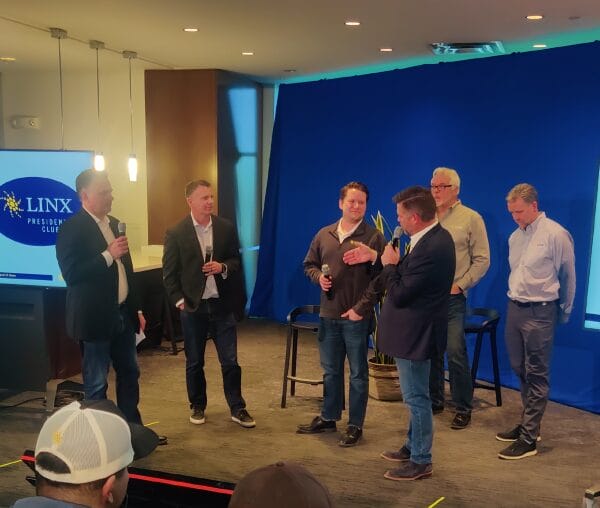 LINX team members presenting on a stage.