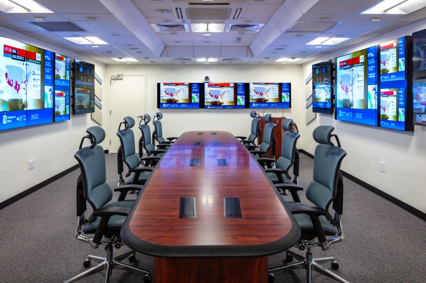 Conference room with a wall-mounted display and integrated audio visual system, skyline view through the windows